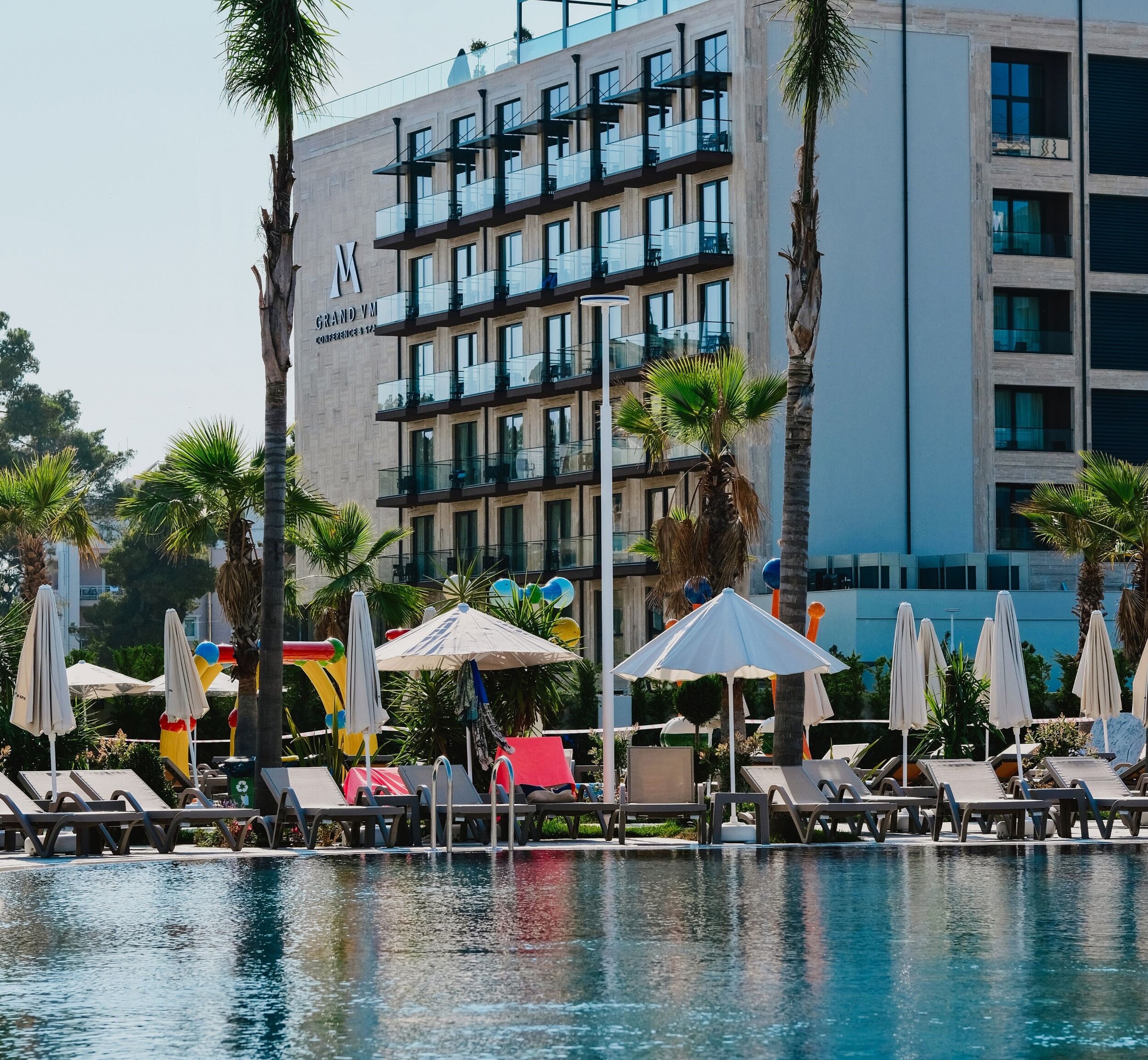 Grand VM Hotel — pool terrace with sun loungers below the hotel facade, Durrës