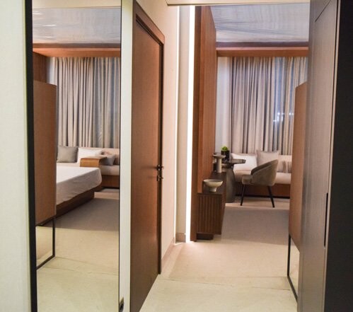 Hilton Kampala mockup room - corridor view into the guest room with wardrobe and armchair, Kampala