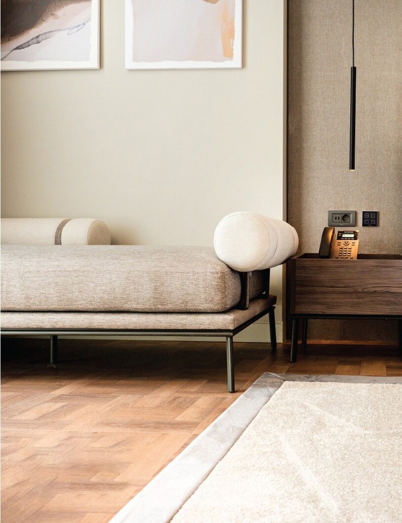 La Brisa Hotel - day bed with a round bolster cushion below framed prints, South Albania