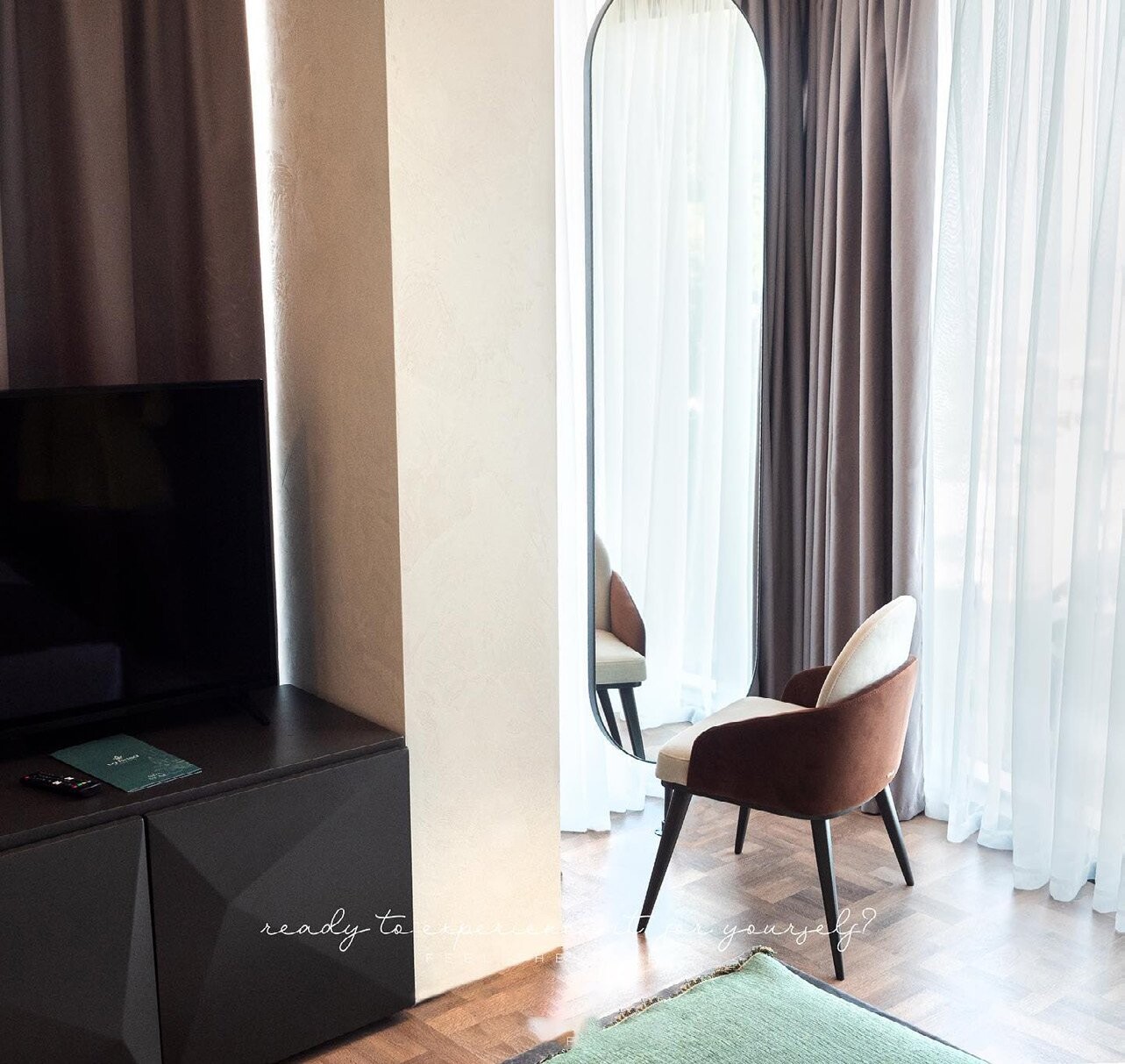 La Brisa Hotel - dark workspace cabinet and upholstered chair beside sheer curtains, South Albania