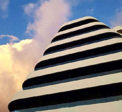 Yacht Hotel — tiered striped facade against the sky, South Albania